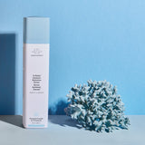 B-Hydra Intensive Hydration Serum Bottle against a blue background with blue coral